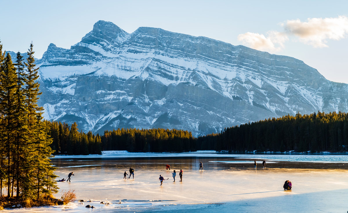 Des gens au loin qui patinent sur un lac gelé.